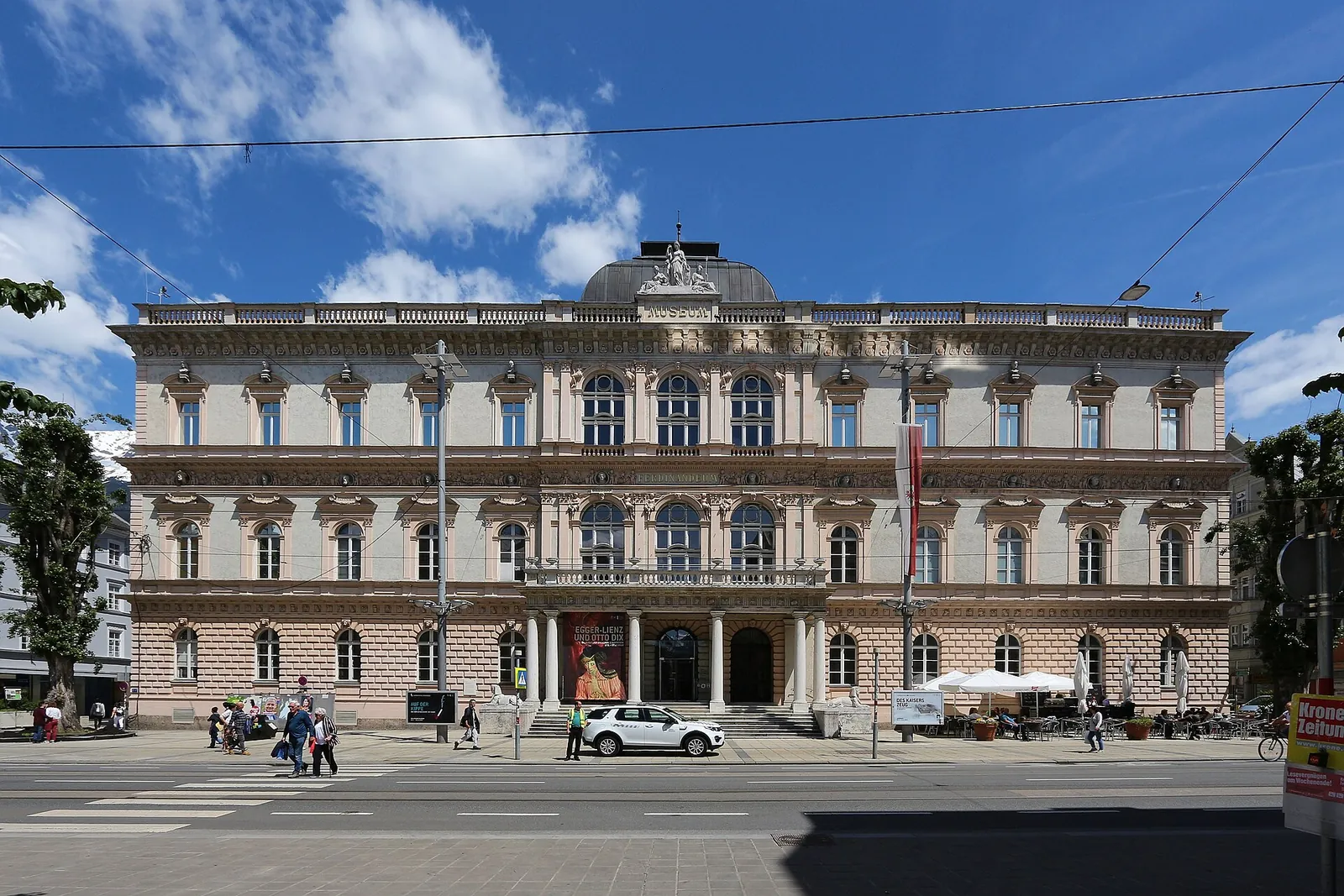 Prachtfassade des Tiroler Landesmuseums Ferdinandeum in der Innsbrucker Museumstraße unter blauem Himmel